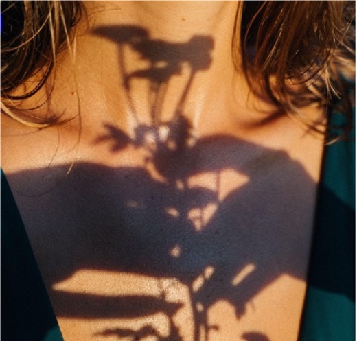 Frau fässt sich an die Schulter